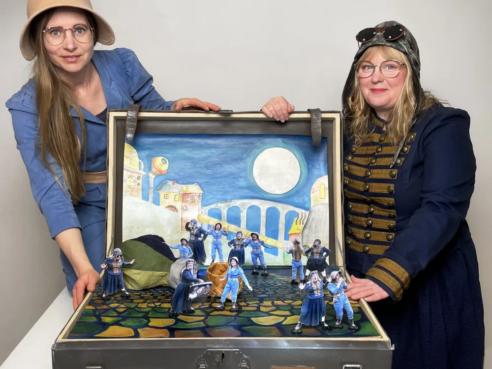 Två kvinnor öppnar en koffert